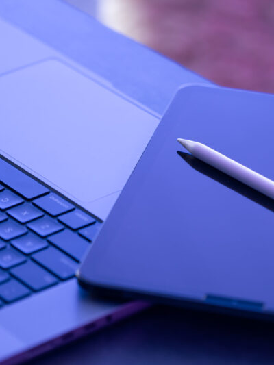 Digital tablet, stylus pen and laptop on the desktop, close up.